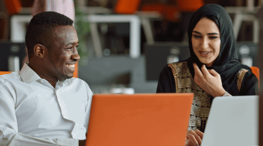 Concept photo of a man and a woman talking while looking at a computer screen.