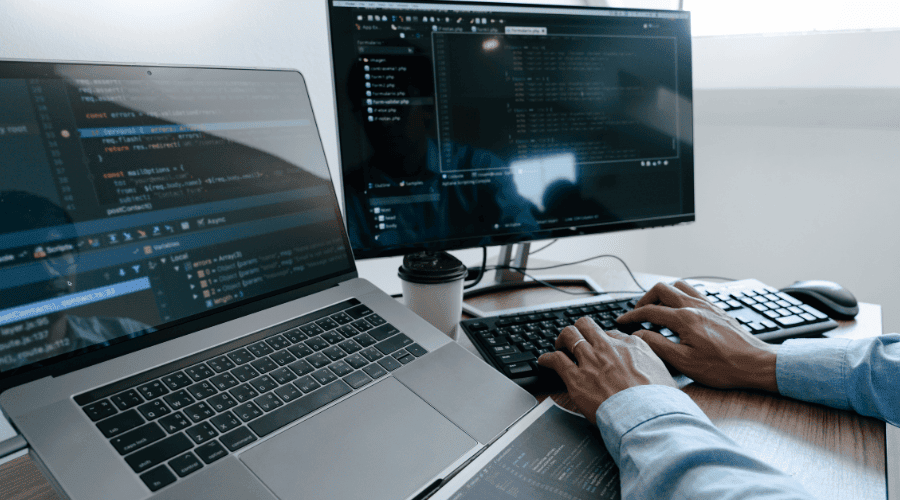 Hands typing code on computer
