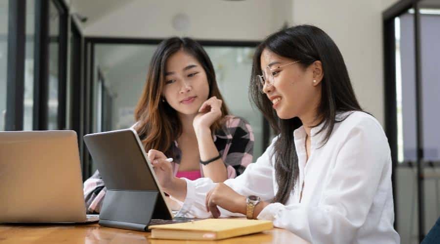 Two women working at a computer.